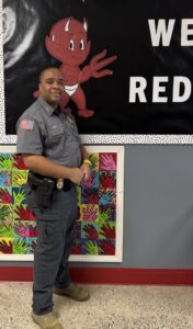 Picture of Darius Ward standing in front of a school bulletin board