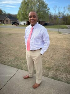 Picture of Darius Ward in suit standing outside on a sidewalk